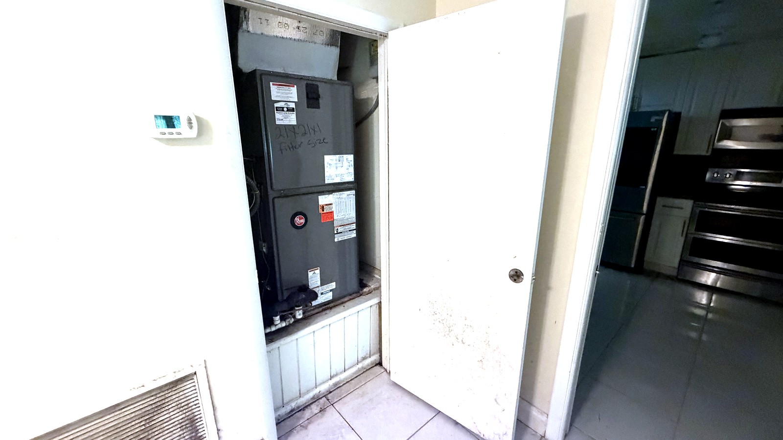 Placard ouvert dans un couloir en Floride, où l'on aperçoit une centrale de traitement d'air présentant des traces de moisissure suite à une fuite dans le toit